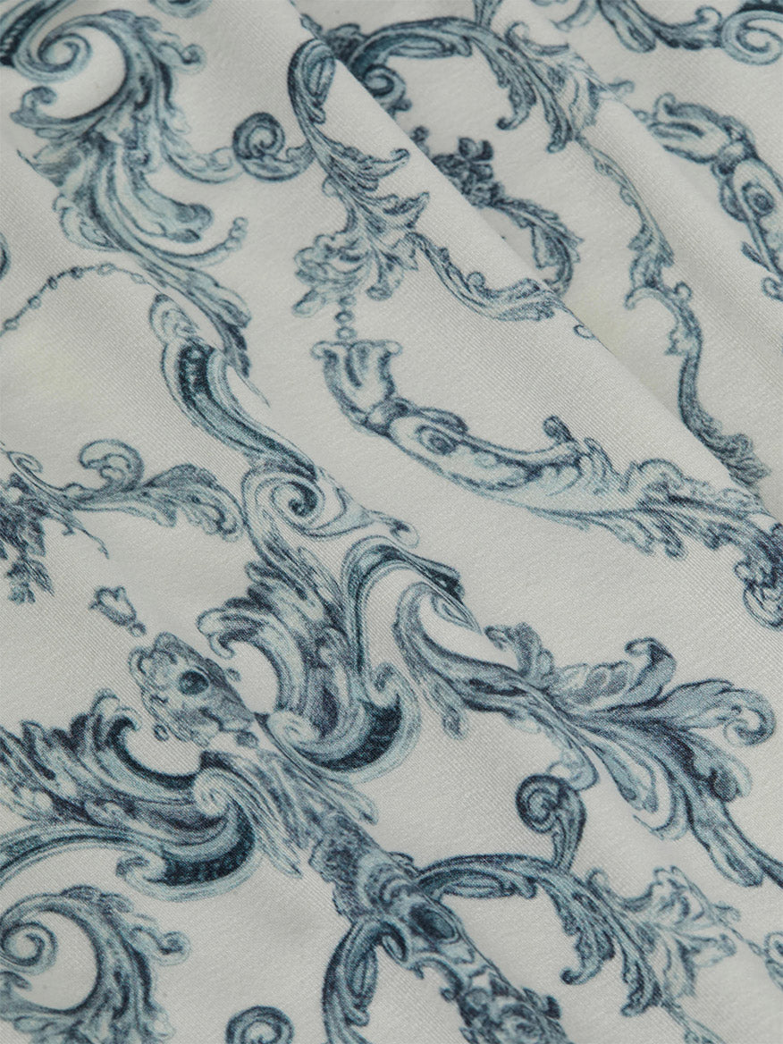 Close-up of the L'Agence Ressi Fitted Tee in Vintage White Blue Scroll Toile, showcasing ornate blue baroque scrolls on white fabric.
