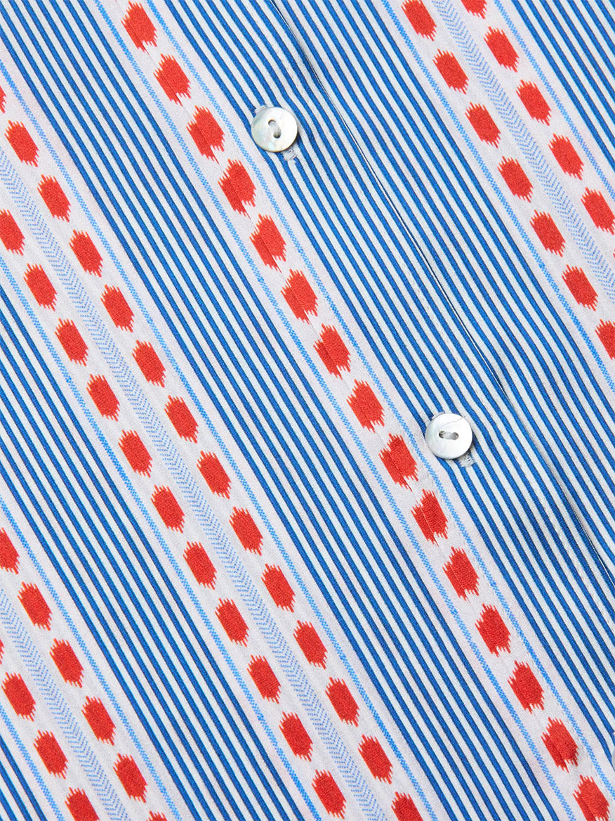 Close-up of the L'Agence Dani Blouse in Blue/Red Textured Stripe Print, a silk button-down with blue stripes, red geometric and leaf-like details, and two white buttons.