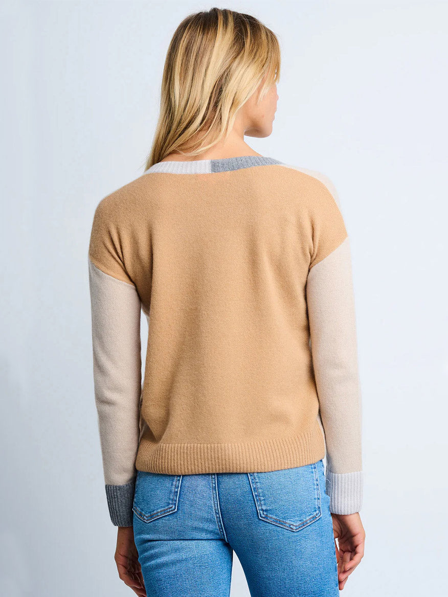A blonde woman is seen from the back wearing the Lisa Todd Color Wheel Sweater in Latte/Caramel, paired with light blue jeans.