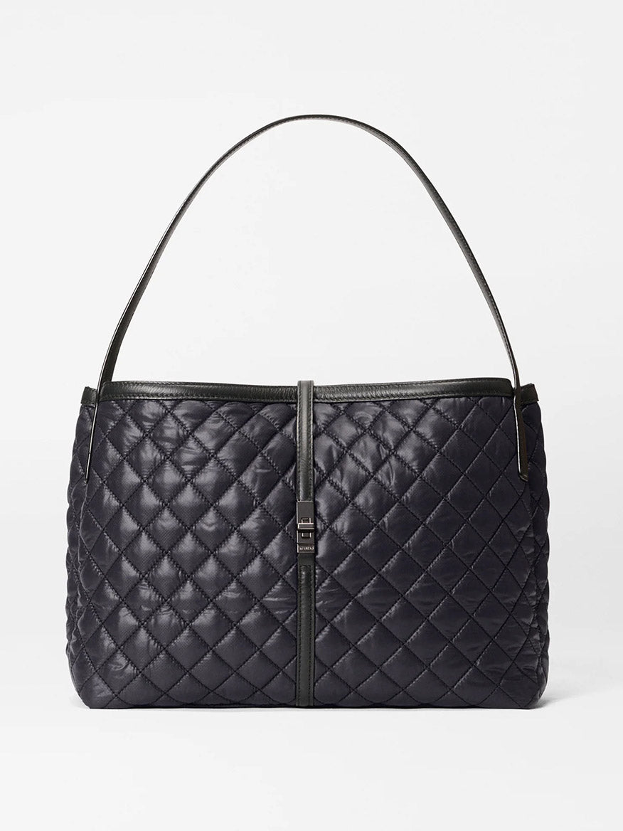 The MZ Wallace Astor East West Tote in Black Oxford features a quilted design, black Italian leather, a single shoulder strap, and a rectangular front clasp, shown against a plain white background.