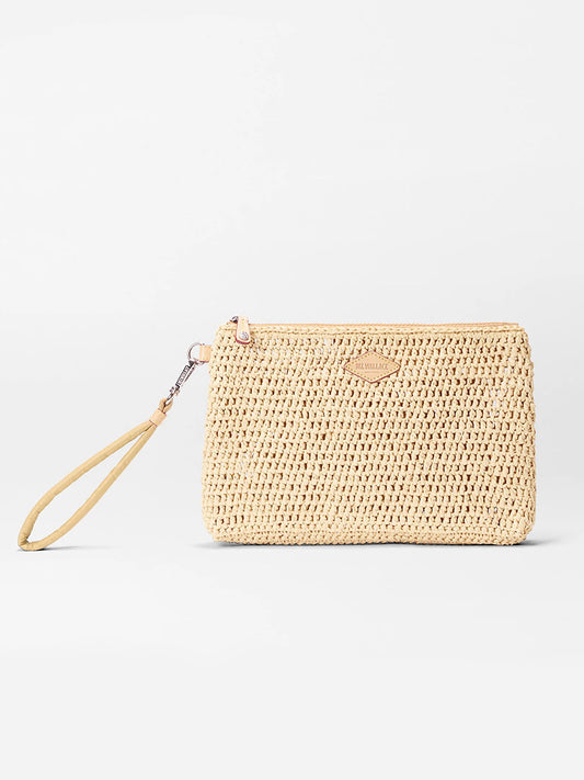The MZ Wallace Crochet Clutch in Crochet/Camel is a rectangular beige woven summer bag with a wrist strap and a small leather patch on the front, shown against a plain white background.