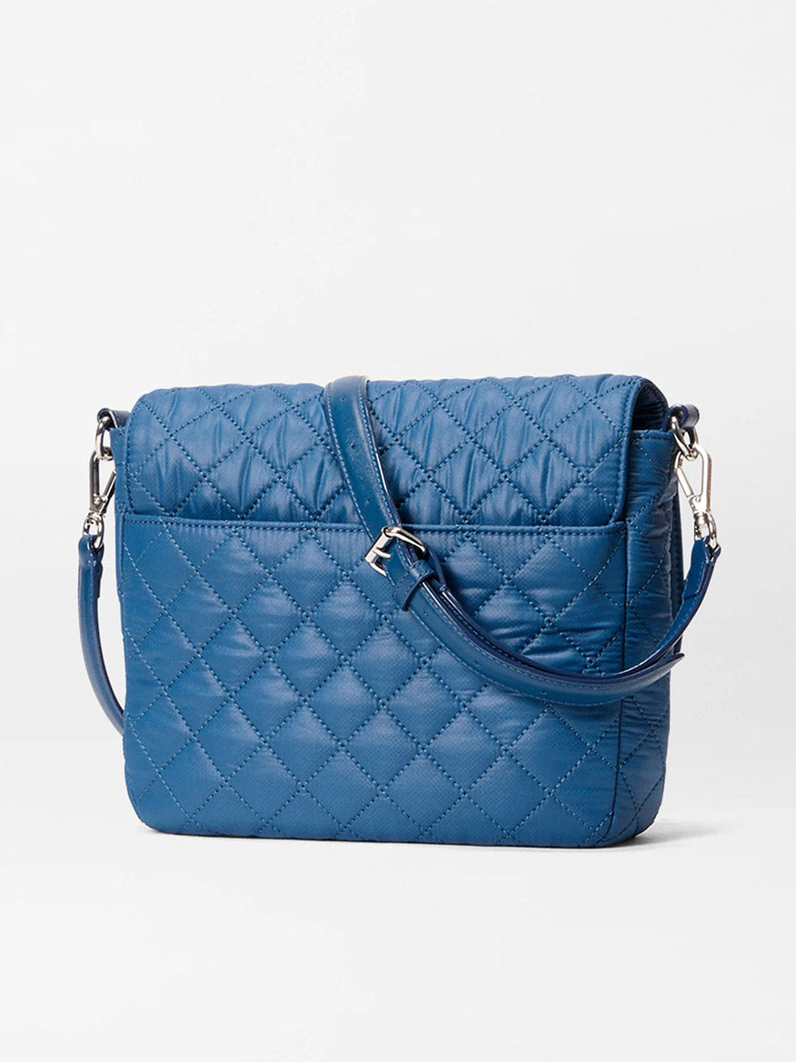 An MZ Wallace Crosby Lock Medium Crossbody in French Blue Oxford with a long adjustable strap and silver hardware, made of quilted nylon, displayed against a plain white background.