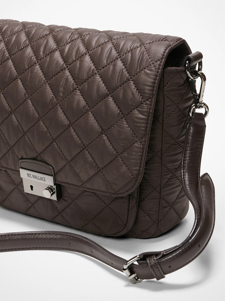 The MZ Wallace Crosby Lock Medium Crossbody in Espresso Oxford features quilted brown leather, a metal clasp, and a detachable strap, shown against a plain white background.