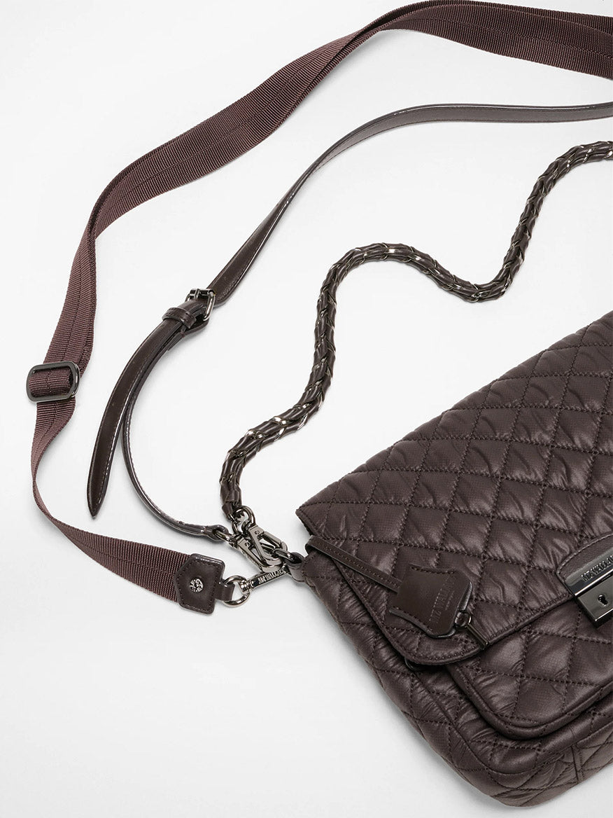 The MZ Wallace Crosby Lock Medium Crossbody in Espresso Oxford, featuring quilted brown leather, a woven chain strap, and an adjustable fabric shoulder strap, is displayed on a white surface.