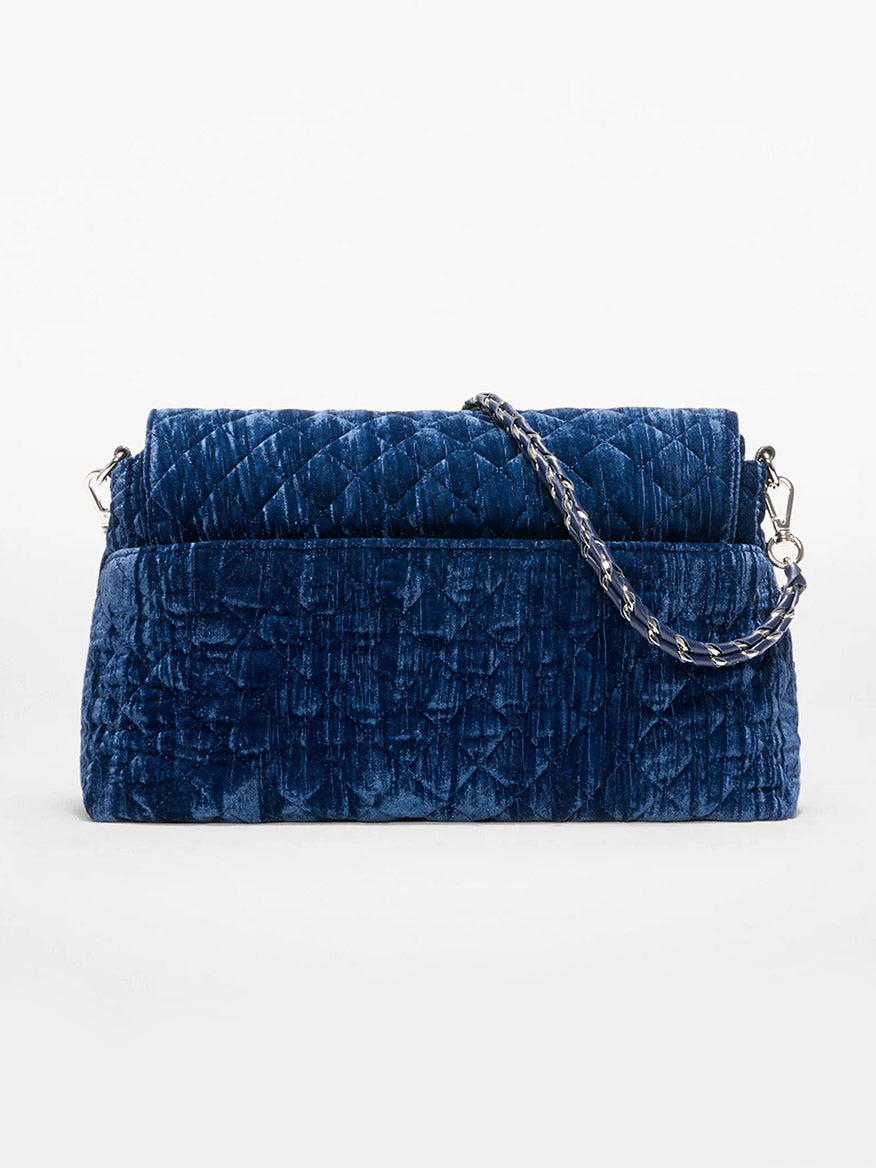 The MZ Wallace Crosby Lock Shoulder in Midnight Velvet, featuring a blue quilted velvet body, Italian leather trim, and a silver chain strap, is displayed against a plain white background.