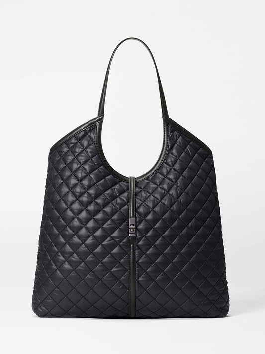The MZ Wallace Large Astor Tote in Black Oxford features a diamond-quilted Oxford fabric, a central zipper, and a single Italian leather handle, shown against a plain white background.