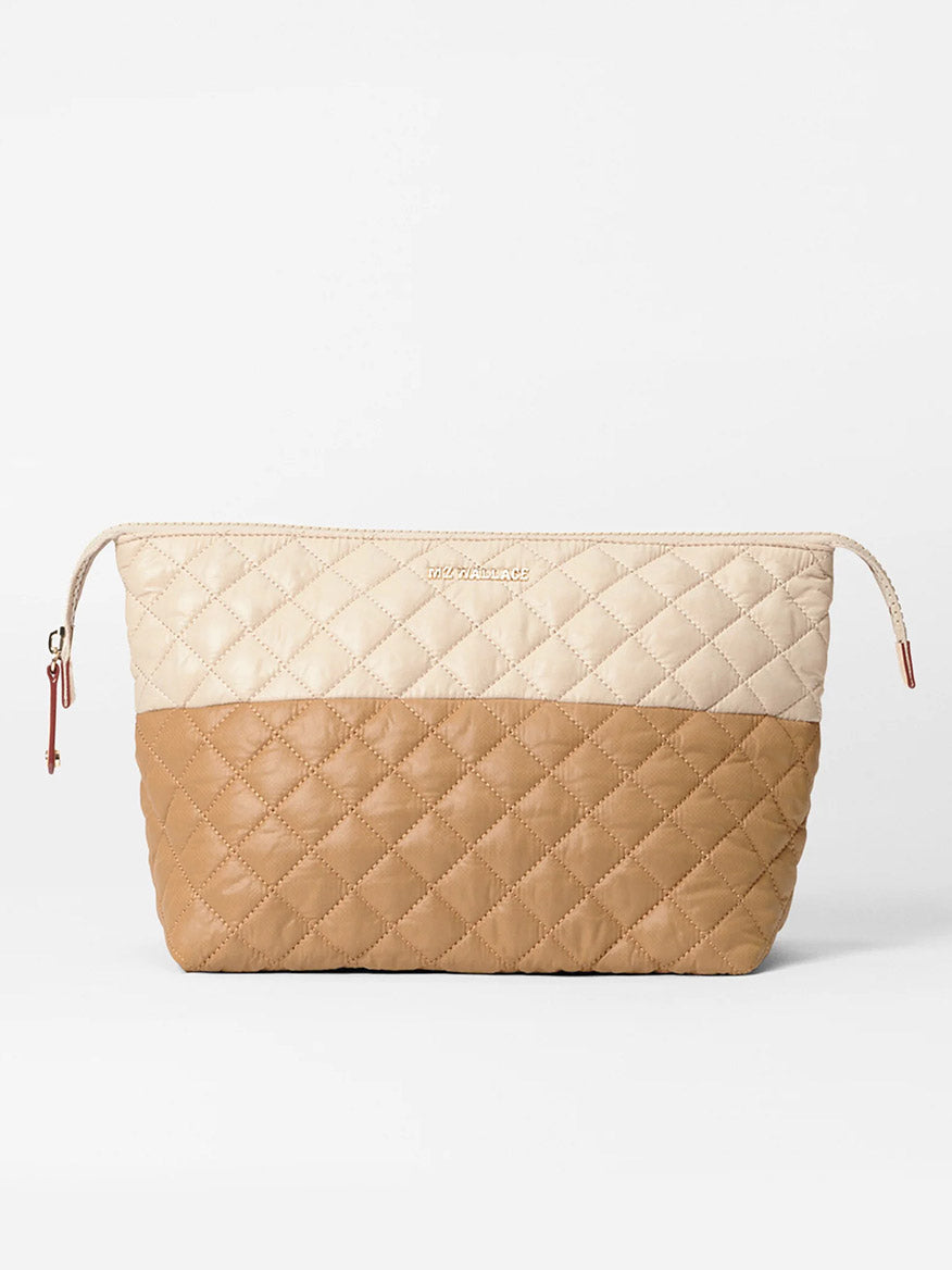 The MZ Wallace Large Zoey Cosmetic in Buff/Caramel Oxford is a quilted, two-tone pouch with a beige top and light brown bottom, ideal for full-size cosmetics, featuring a zipper closure and subtle front branding.