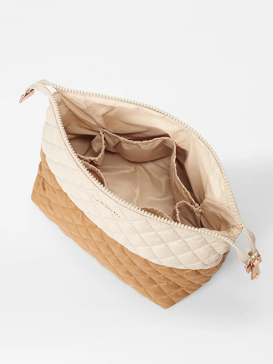 The MZ Wallace Large Zoey Cosmetic in Buff/Caramel Oxford is a quilted two-tone zip pouch with multiple inner pockets, ideal for stylishly storing full-size cosmetics on the go.