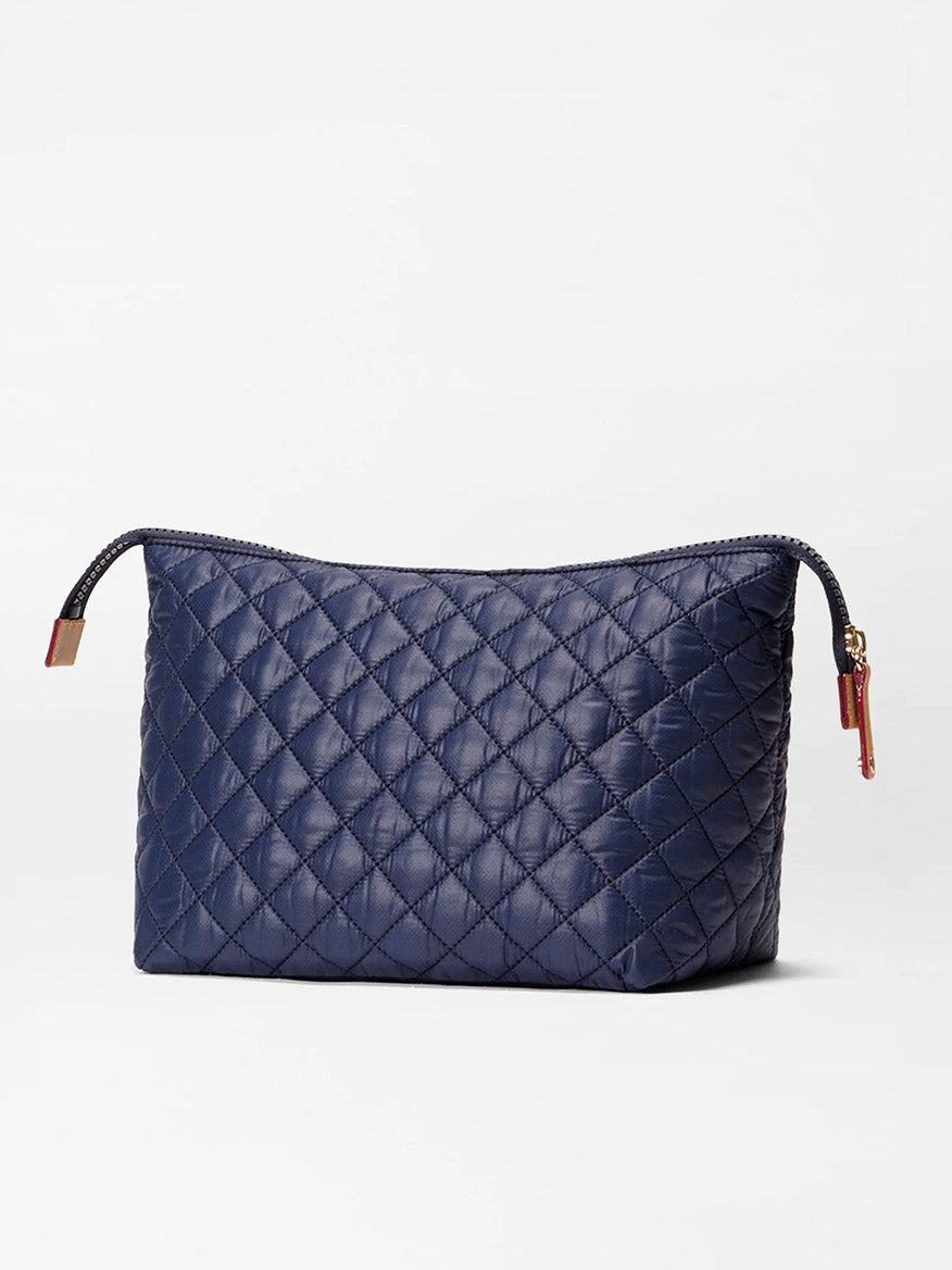 The MZ Wallace Large Zoey Cosmetic in Anchor Oxford is a navy quilted rectangular pouch with a zipper closure, ideal for travel essentials, displayed against a plain white background.