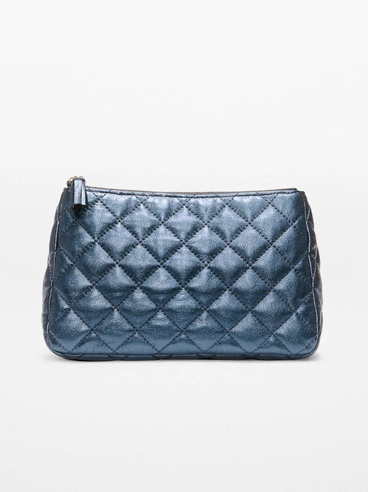 The MZ Wallace Medium Luna Cosmetic in Midnight Metallic Leather features a quilted metallic blue finish, light gold hardware, and a zipper closure, shown against a plain white background.