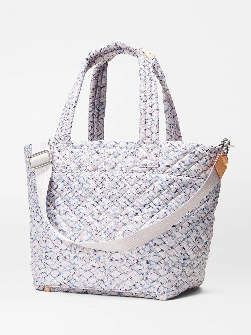 MZ Wallace Medium Metro Tote Deluxe in Summer Shale Oxford fabric with shoulder strap and luggage sleeve on a white background.