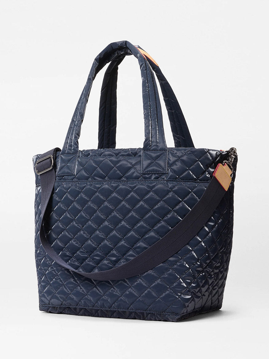 The MZ Wallace Medium Metro Tote Deluxe in Ink Liquid Oxford, featuring two short handles and a detachable shoulder strap, is perfect as a travel or laptop tote and shown against a plain white background.