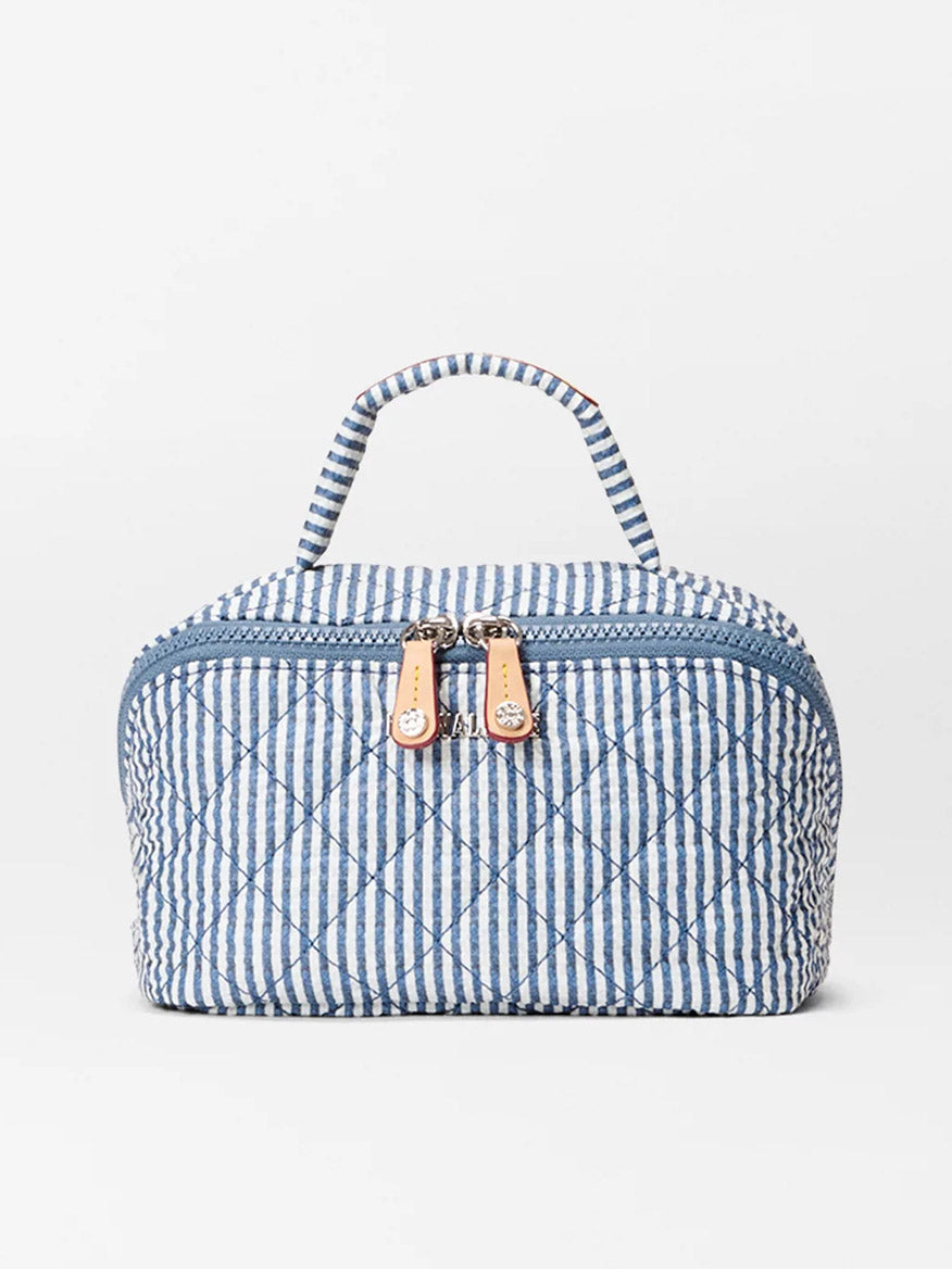 The MZ Wallace Metro Accordion Cosmetic in Seersucker Oxford is a blue and white striped quilted nylon bag with a top handle and dual front zipper pulls, ideal for keeping your essentials organized while traveling.