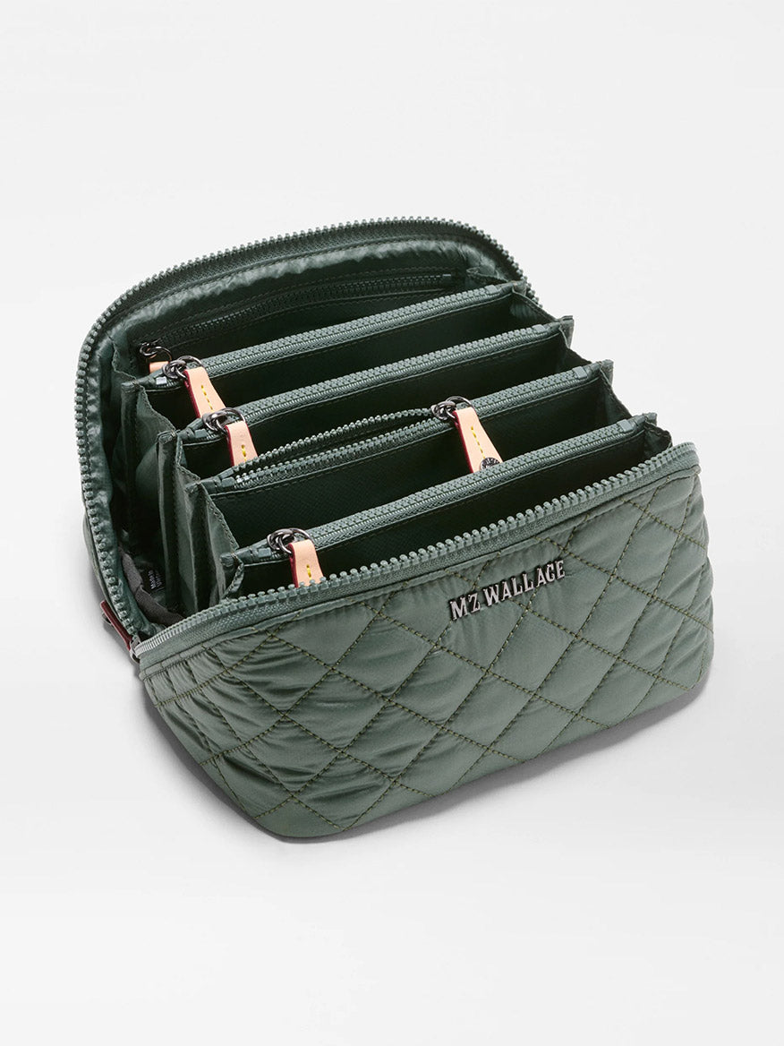 Introducing the MZ Wallace Metro Accordion Cosmetic II in Juniper Oxford—a green quilted organizer pouch made from recycled Oxford nylon, featuring multiple zippered compartments with tan pull tabs and the “MZ WALLACE” logo on the front.
