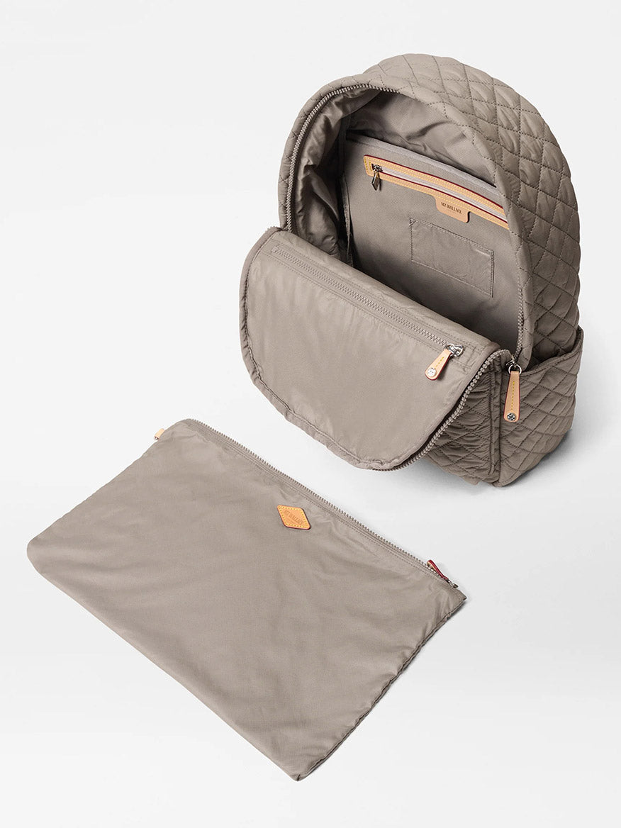 The MZ Wallace Metro Backpack II in Morning Dove Oxford features a quilted beige exterior, Italian leather trim, an open top revealing inner pockets, and comes with a separate flat zippered pouch placed in front.