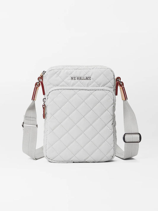 White MZ Wallace Metro Crossbody in Pebble Liquid Oxford quilted bag with an adjustable crossbody strap, external pocket, and zipper details.