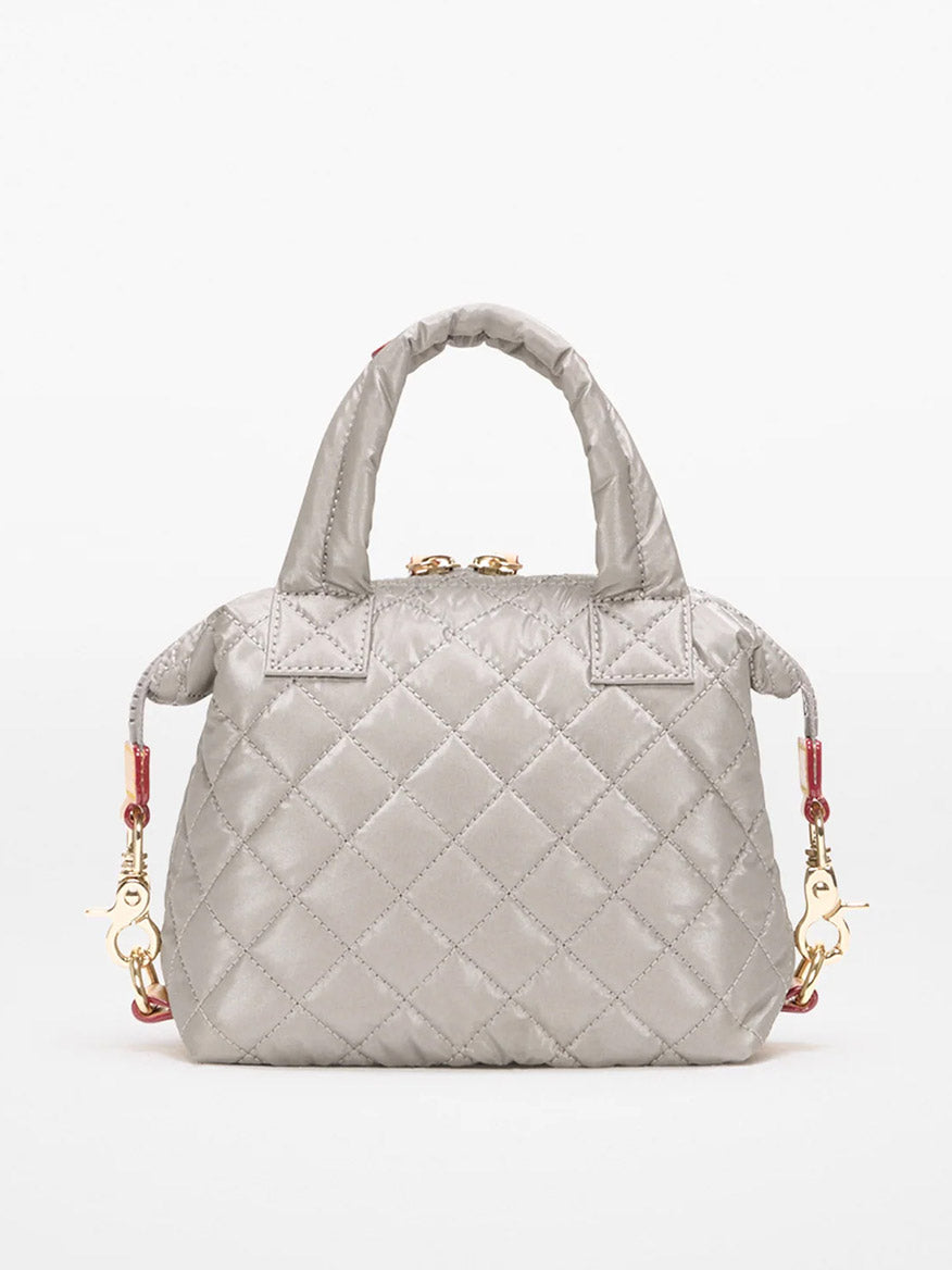 The MZ Wallace Micro Sutton in Sable Pearl Metallic Oxford is a small quilted gray handbag with short handles, gold hardware, and detachable clasps for an optional crossbody strap, shown against a plain white background.