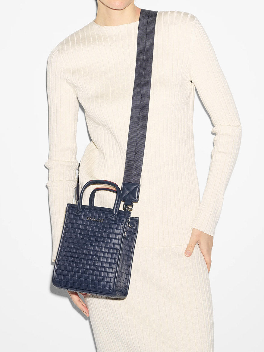 Woman in a cream ribbed dress holding a MZ Wallace Micro Woven Box Tote in Dawn Oxford with Italian leather trim and a shoulder strap.