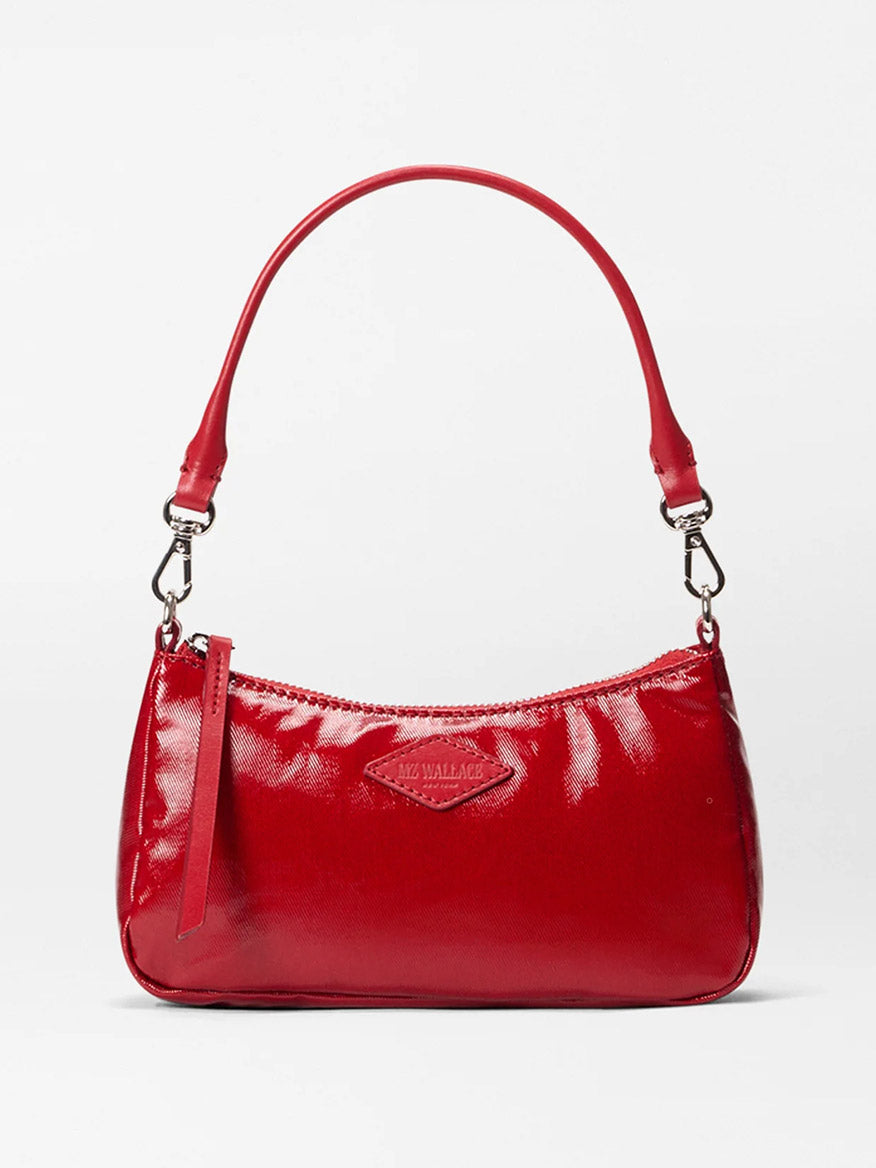 The MZ Wallace Mini Chelsea Shoulder in Apple Gloss Bedford is a small, shiny red bag with one short handle, silver hardware, zipper closure, Italian leather trim, and a subtle embossed front logo.