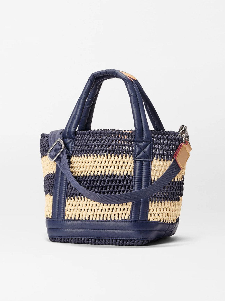 The MZ Wallace Mini Crochet Tote in Dawn/Natural Stripe Crochet features navy and beige stripes, navy handles, a detachable shoulder strap, and denim trim, displayed on a plain white background.