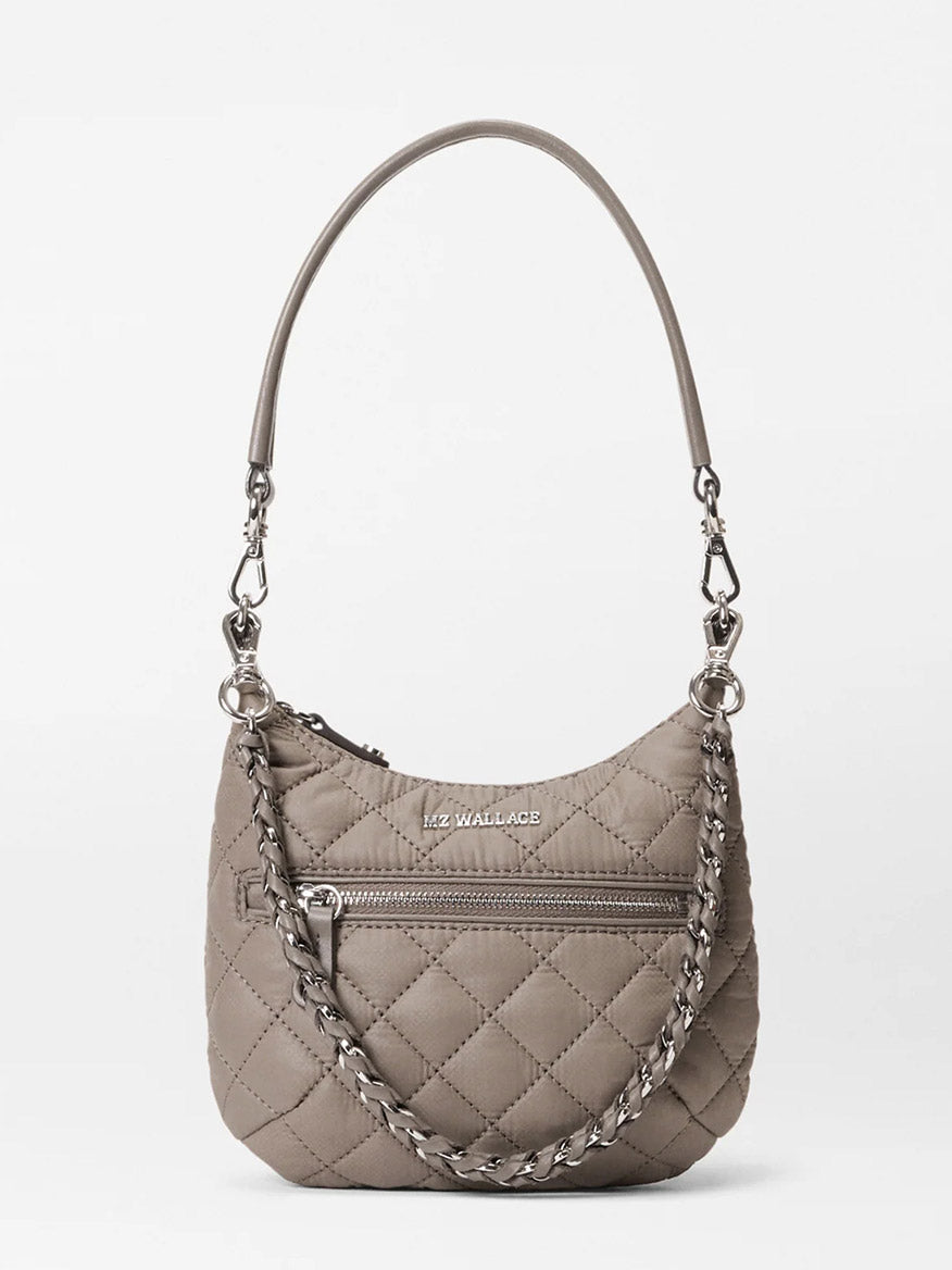 The MZ Wallace Mini Crosby Sienna in Morning Dove Oxford features a taupe quilted design, front zipper pocket, chain and leather strap, and logo on the front—making it a stylishly versatile everyday shoulder satchel.