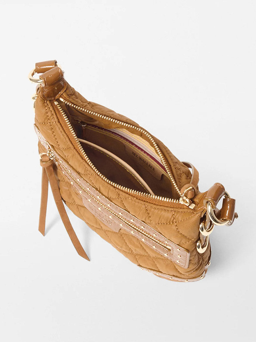 The MZ Wallace Mini Multi Stud Crosby Sienna in Amber Stud & Suede is a tan quilted crossbody bag with Italian leather trim, gold hardware, an exterior zip pocket, and an open main compartment, viewed from above.