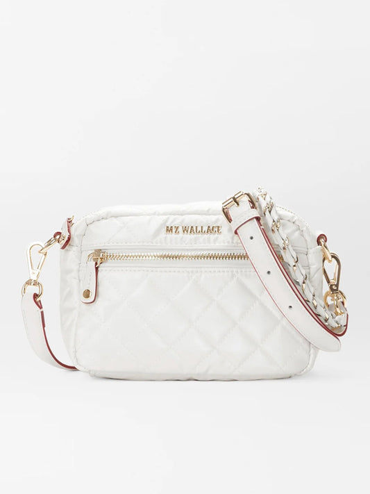 White quilted MZ Wallace Mini Crosby in Pearl Metallic Oxford purse with a gold chain strap and exterior zipper, displayed against a plain background.