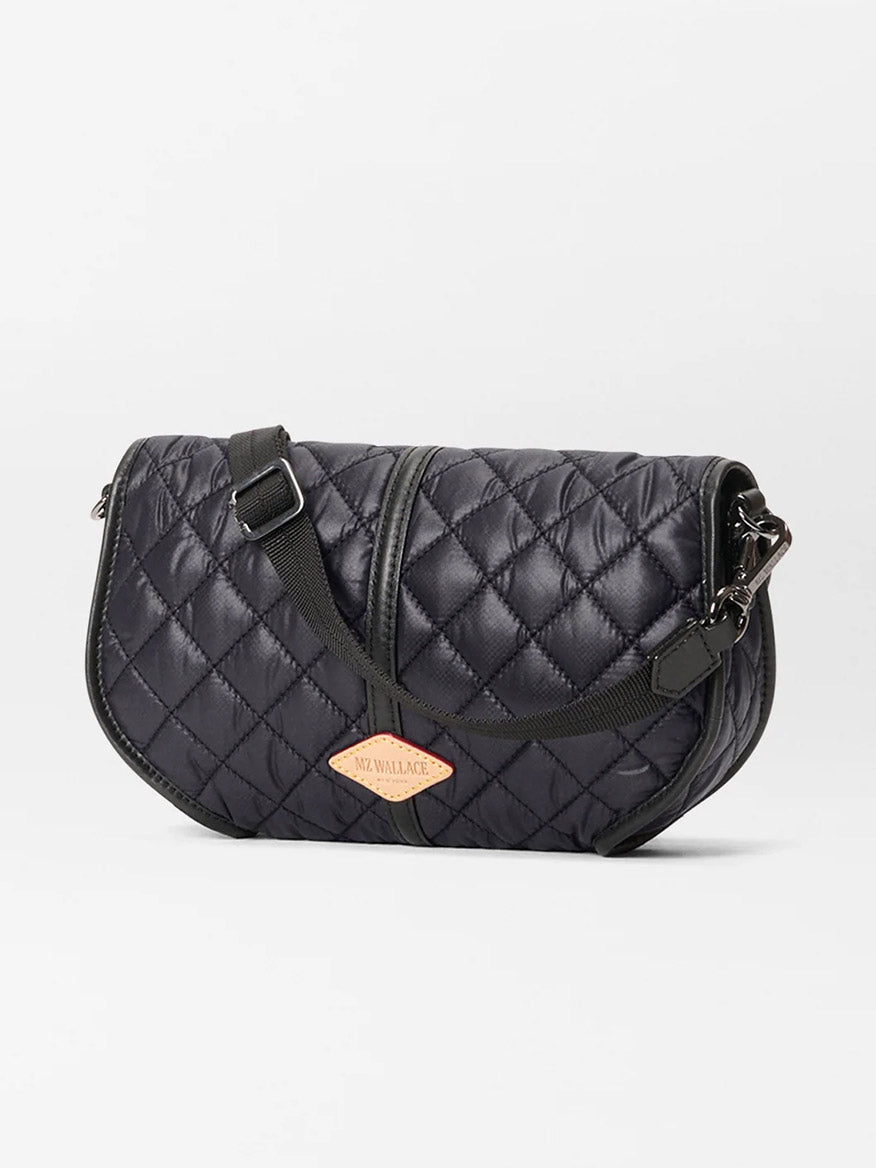 The MZ Wallace Small Astor Convertible Clutch in Black Oxford is a black quilted crossbody bag with Italian leather, a front zipper, adjustable strap, and a tan "MZ Wallace" patch label.