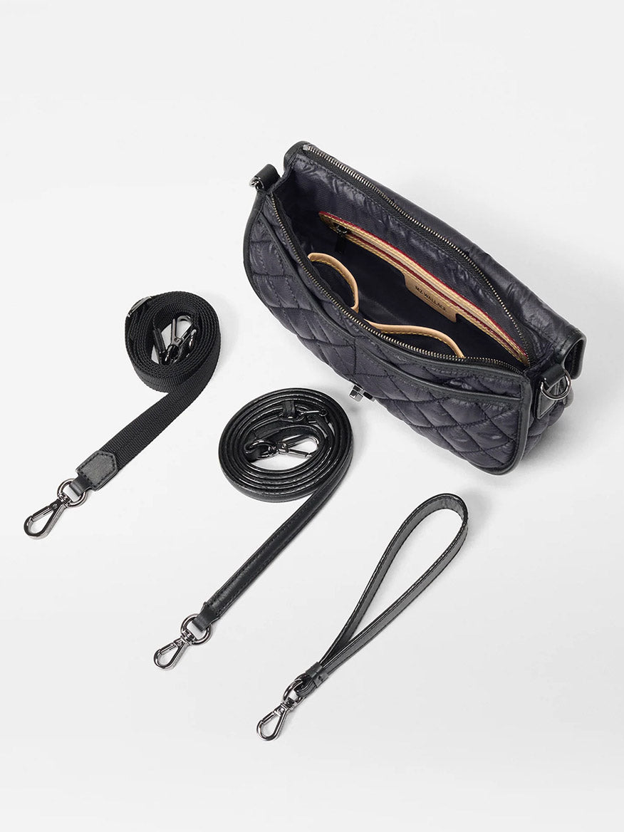 The MZ Wallace Small Astor Convertible Clutch in Black Oxford features quilted Italian leather, an open zipper revealing contents, and three detachable straps: a fabric strap, a leather crossbody, and a leather wristlet.