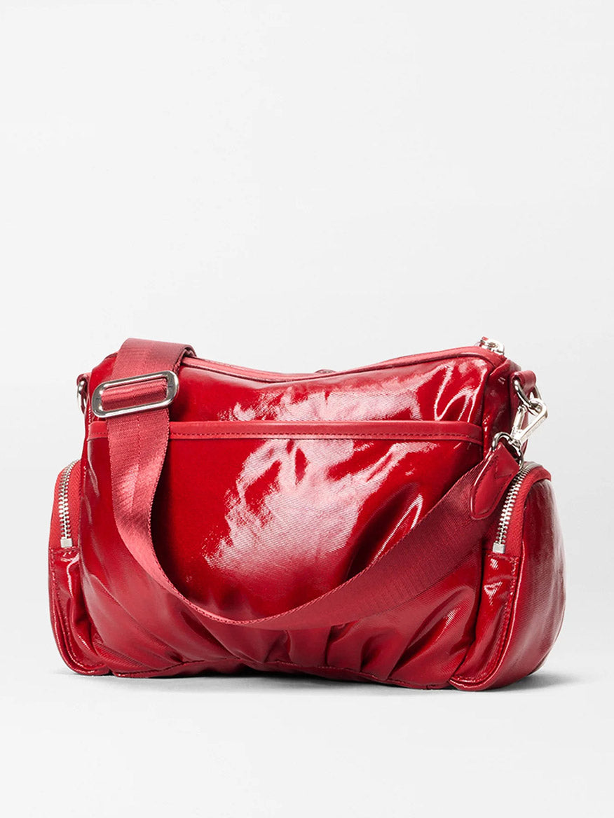 The MZ Wallace Small Chelsea Crossbody in Apple Gloss Bedford, featuring a wide adjustable strap, front zipper pocket, and two side zip compartments, is displayed on a plain white background.