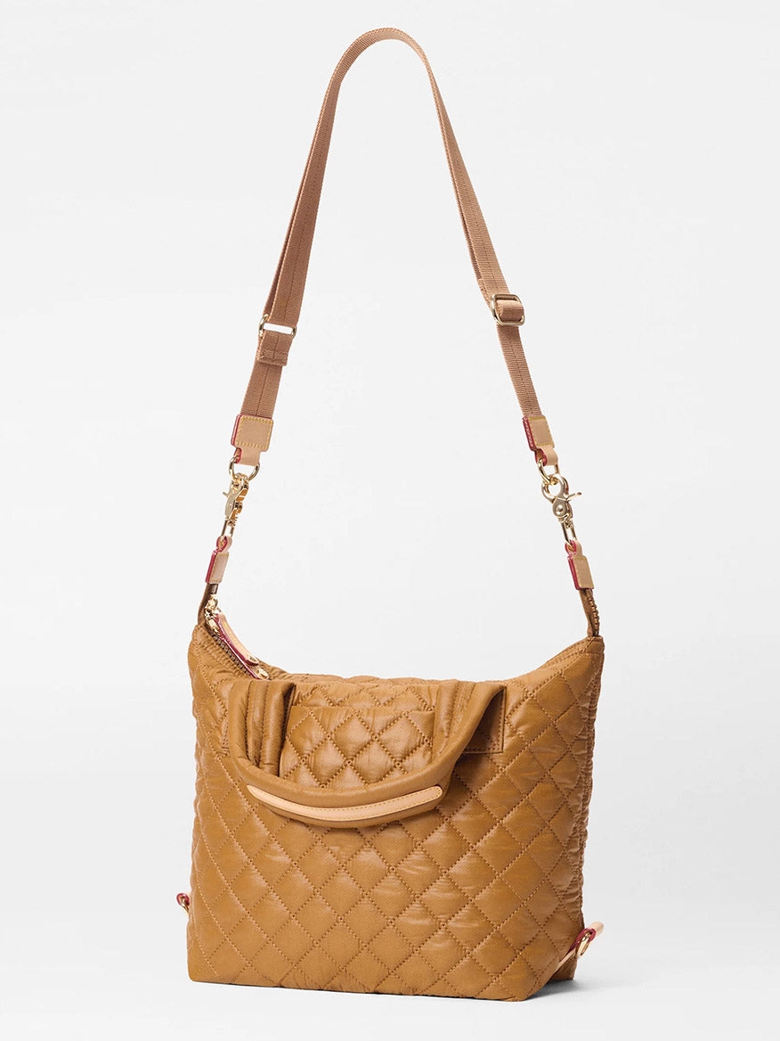 MZ Wallace Small Sutton Deluxe in Amber Oxford shown against a plain white background, featuring quilted Italian leather, an adjustable strap, gold hardware, and a curved top handle.