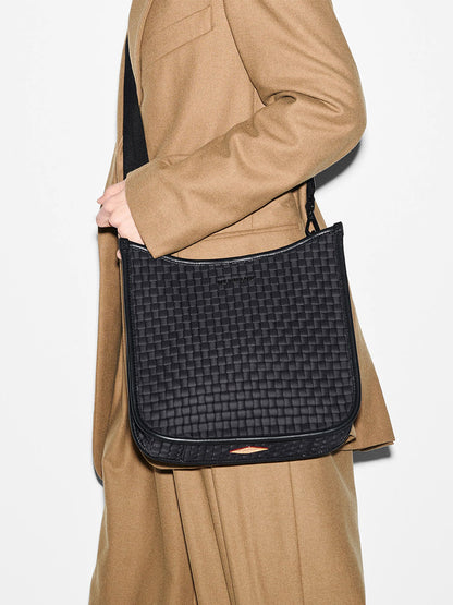 Woman in a beige coat carrying a MZ Wallace Woven Box Crossbody in Black Oxford with Italian leather trim.