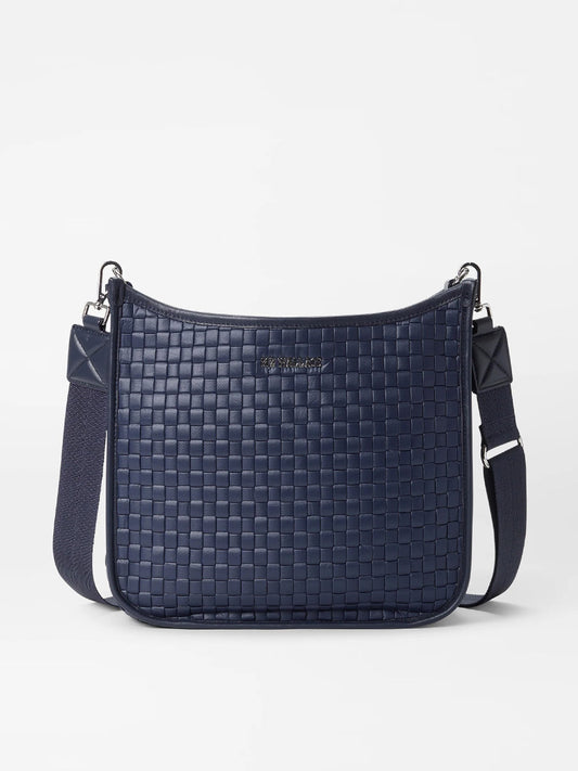 The MZ Wallace Woven Box Crossbody in Dawn Oxford, with an adjustable strap, is handwoven with a blue pattern and is shown against a white background.
