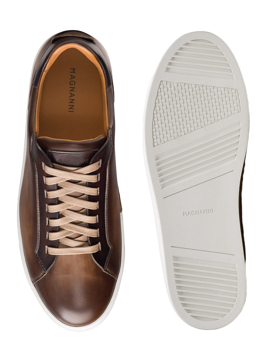 The Magnanni Amadeo in Taupe & Brown is a cupsole fashion sneaker made in Spain, featuring beige laces and a white textured rubber sole for a refined, luxurious look. Shown from above and below.