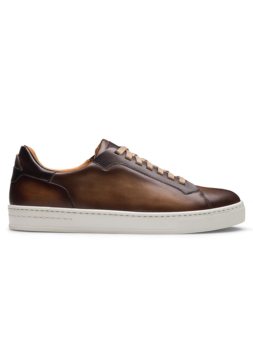 Magnanni Amadeo in Taupe & Brown: luxury brown leather sneaker with beige laces and a white rubber cupsole, shown in profile against a white background. Crafted in Spain for refined, modern style.