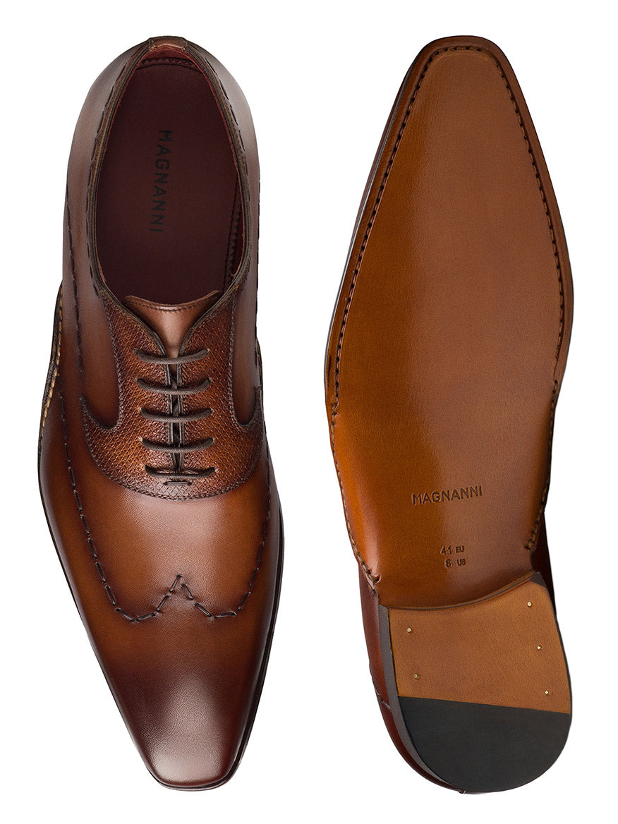 The Magnanni Bowden in Cognac dress shoes highlight elegance and craftsmanship with brogue detailing, featuring a top and sole view for refined style lovers.