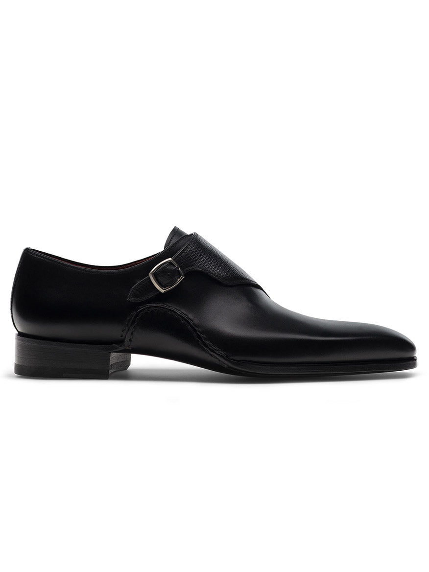 The Magnanni Carver in Black is a sleek black leather monk strap shoe with Bologna construction for enhanced comfort, single buckle design, and a flat sole, displayed on a plain white background.