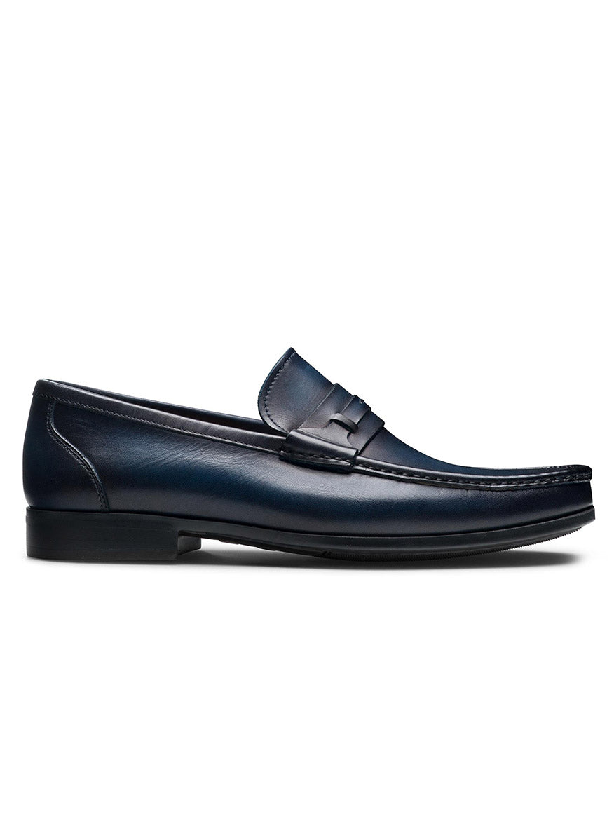 The Magnanni Daren in Navy is a leather penny loafer with a low heel, moccasin toe stitching, and a penny strap detail, shown from the side against a white background.