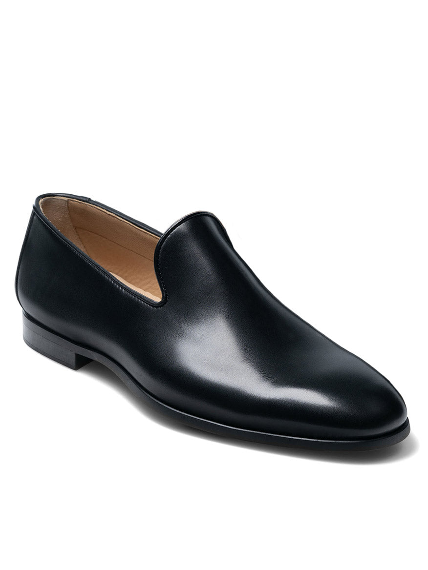 The Magnanni Diaz in Black is a calfskin leather venetian loafer with a low heel and smooth finish, crafted in Spain and displayed on a white background.