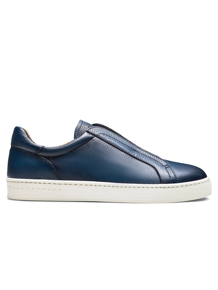 The Magnanni Gasol in Tumbled Navy is a dark blue leather slip-on sneaker with a white sole, featuring an elastic gore system and zipper for easy wear.