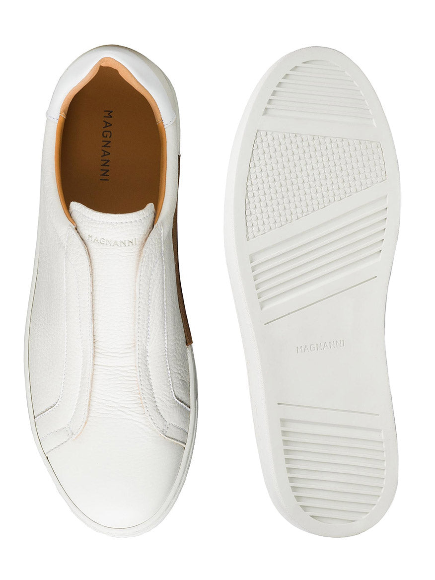The Magnanni Gasol in Tumbled White are leather slip-on sneakers with an elastic gore for a snug fit, featuring a textured sole. "MAGNANNI" is visible inside the shoe and on the Artesano sole, enhancing its clean design.