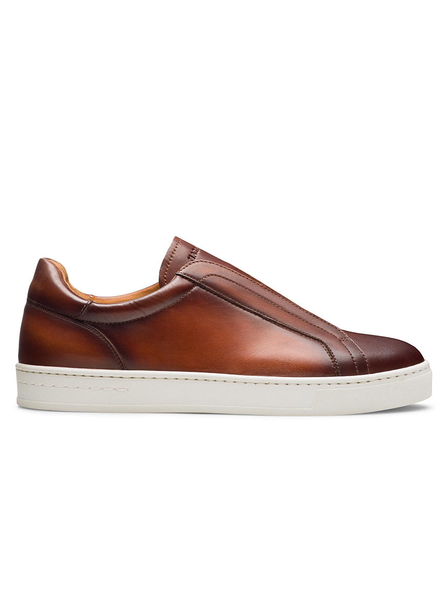 A side view of the Magnanni Gasol in Cognac showcases its brown leather design with a stitched leather insert and a white rubber sole, complemented by an elastic gore system for easy wear.
