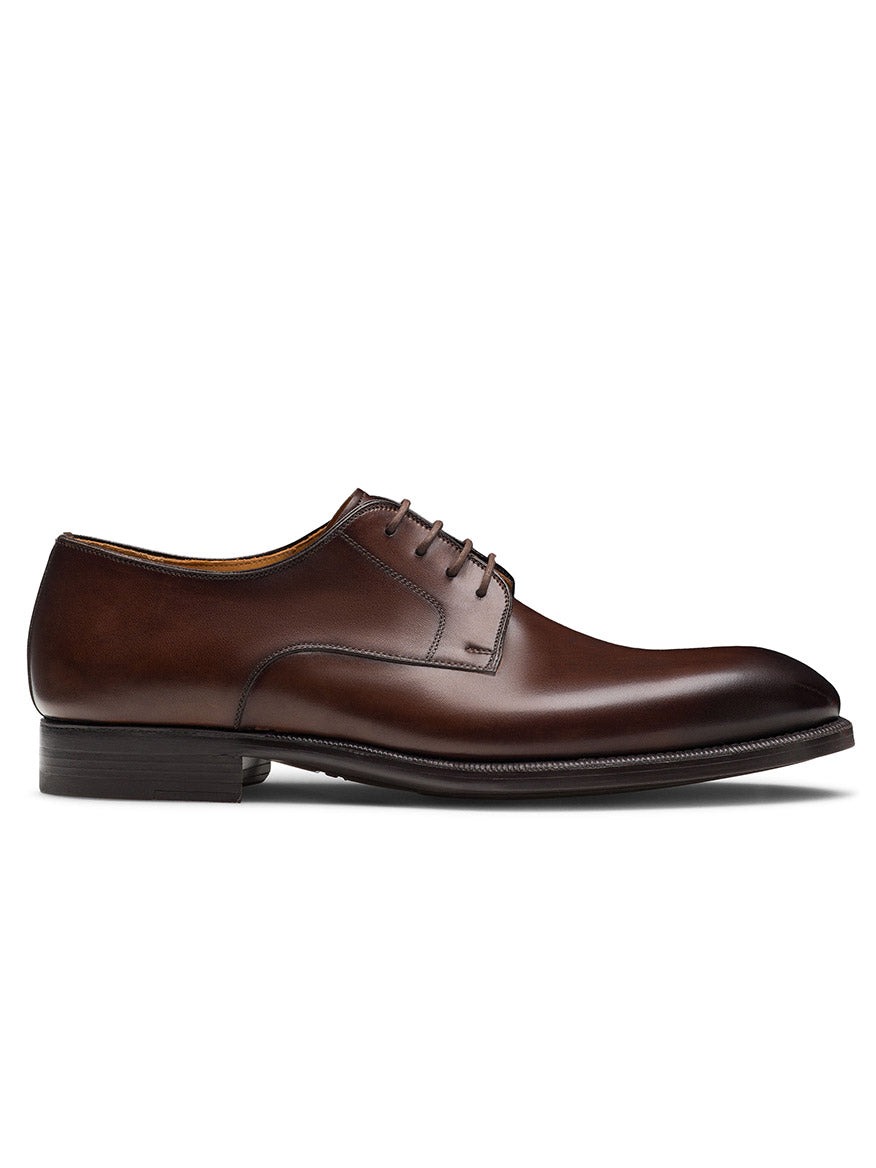 The Magnanni Haans in Brown is a men's plain toe derby dress shoe featuring brown leather, laces, a low heel, and a polished finish—shown in side profile against a white background—ideal for elevating your business attire.