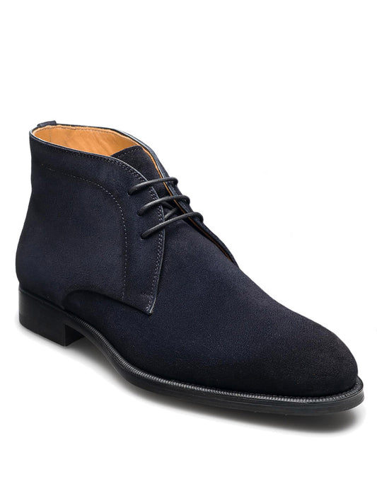 A Magnanni Harvy in Navy Suede chukka boot with black laces, a padded insole, and a small heel, isolated on a white background.