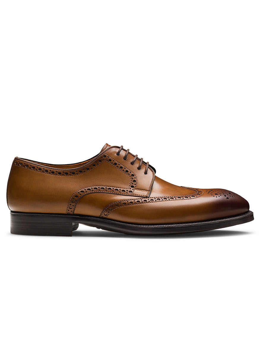 The Magnanni Heyward in Tabaco is a brown leather brogue wingtip derby with classic detailing, black sole, and laces, displayed in side profile against a white background.