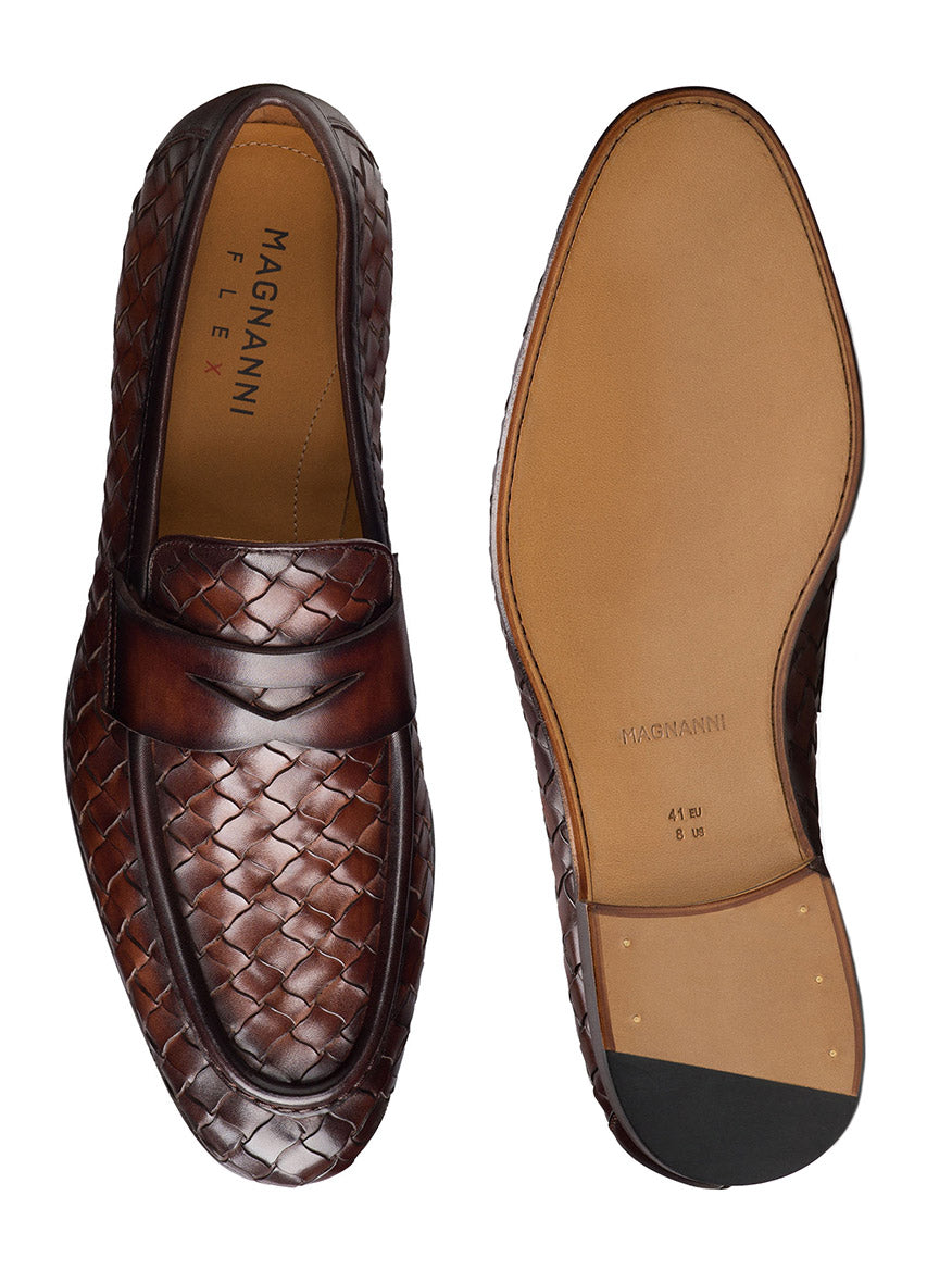 The Magnanni Hyde in Midbrown penny loafers, hand-woven with Bologna construction, showcase Línea Flex craftsmanship. Viewed from the top and bottom, they highlight the "Magnanni" branding on their insoles and soles, reflecting exceptional flexibility and finesse.