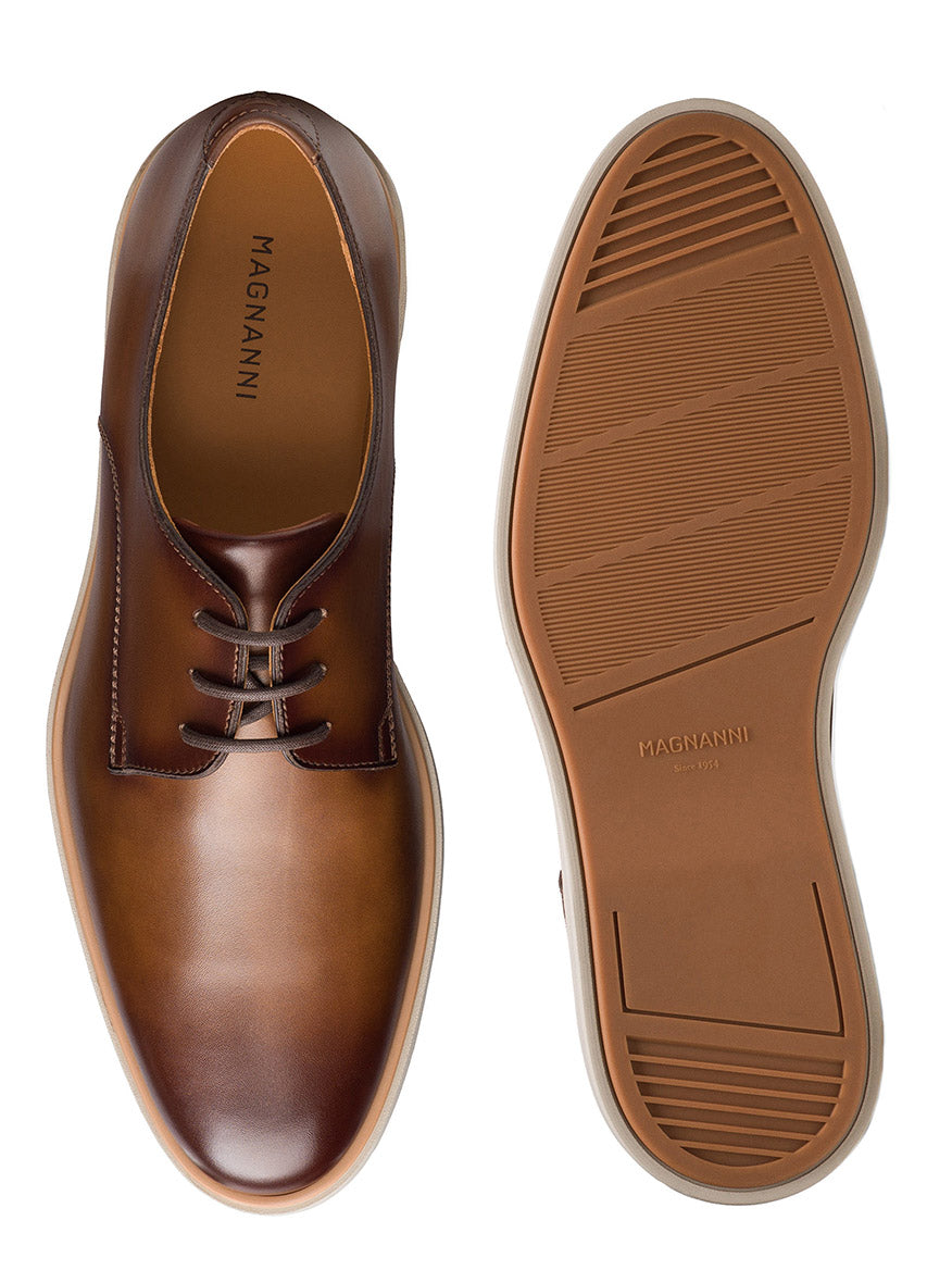 The Magnanni Leone II in Tabaco features a leather upper, light brown rubber outsoles, and a classic lace-up design, combining dress shoe style with hybrid comfort.