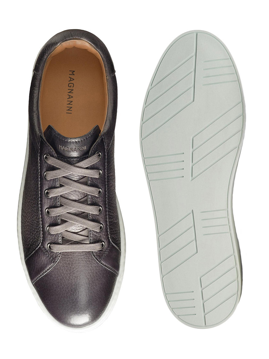 A single Magnanni Leve in Grey tumbled deerskin leather sneaker with its sole displayed next to it.