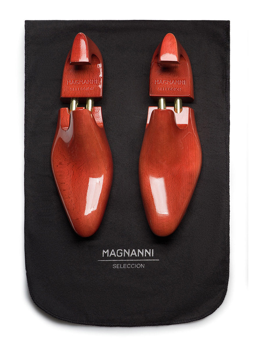 Wooden shoe trees are showcased on a black cloth with the "Magnanni Seleccion" text, reflecting the craftsmanship of the Magnanni Marquis in Brown.