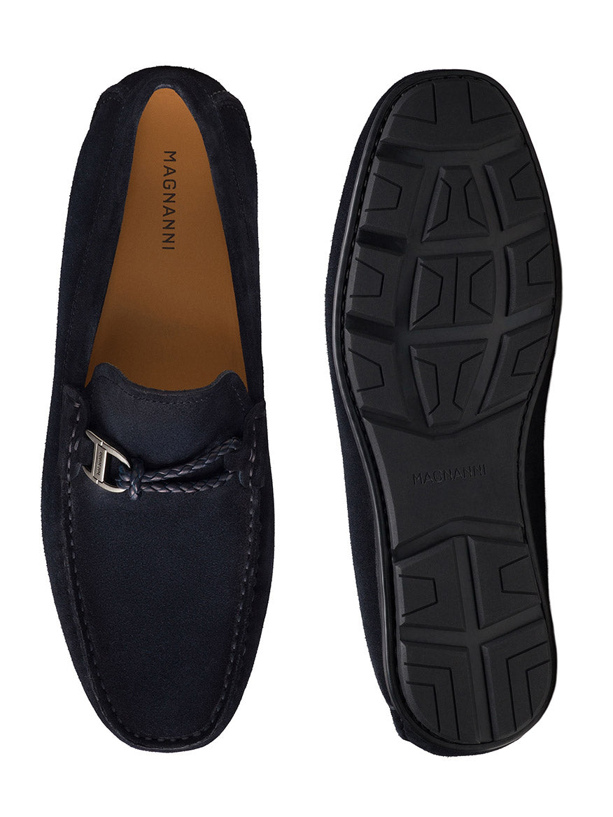 A pair of navy suede slip-on driving loafers, branded as "Magnanni Monterey Braid Bit," showcasing a buckle and featuring top and sole views. The brand "Magnanni" is elegantly displayed on both the insole and sole.